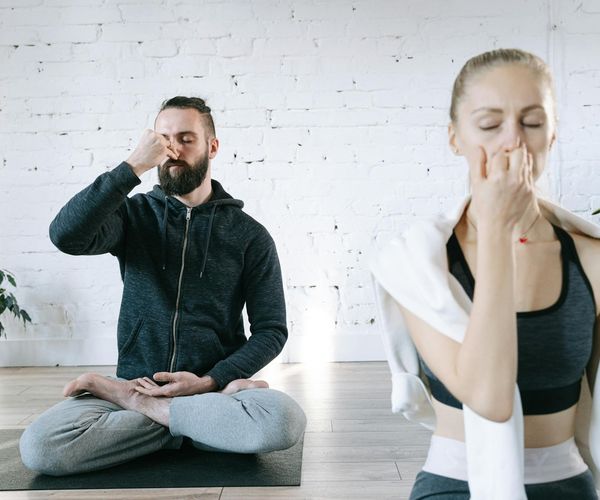 Person meditating peacefully in a bright, sunlit room.